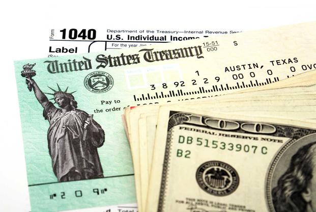 Cash and check with tax form signifying tax refund