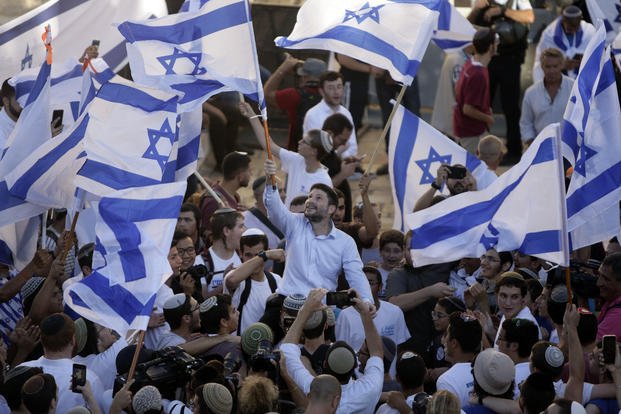 Israel Palestinians wave an Israeli flag.