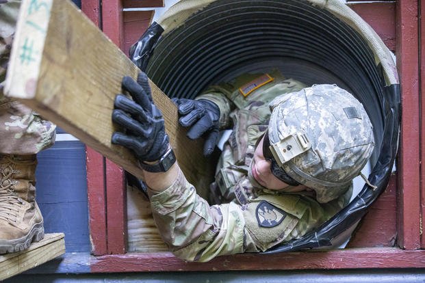 Cadet navigates his way through a tunnel during Cadet Field Training