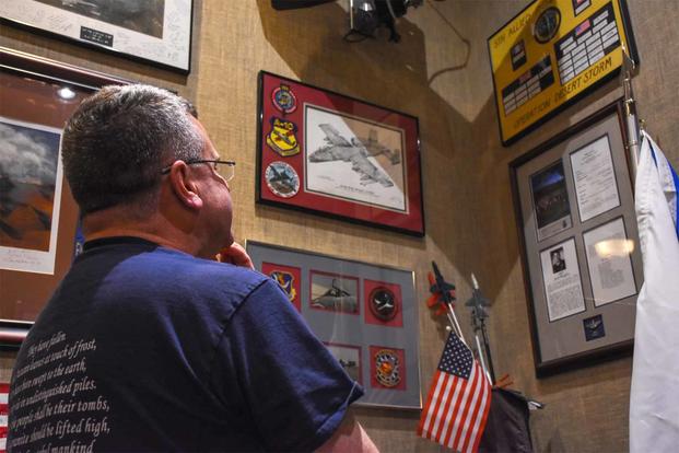 Lt. Col. Rob Sweet stares at his prisoner of war memorabilia.