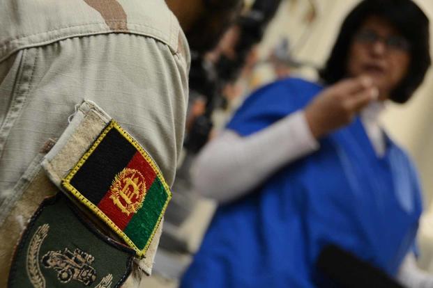 An Afghan soldier listens to an interpreter