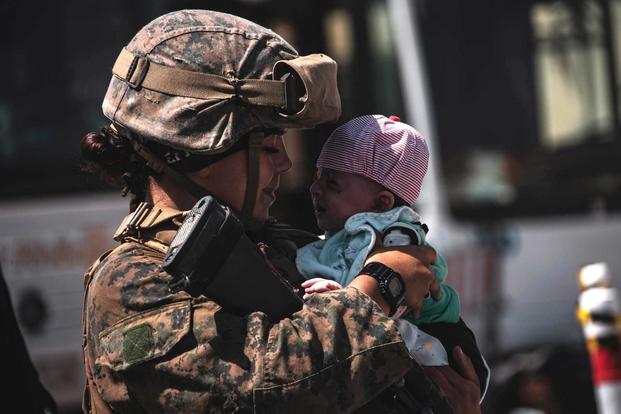  A Marine assigned to the 24th Marine Expeditionary Unit (MEU) calms down an infant.