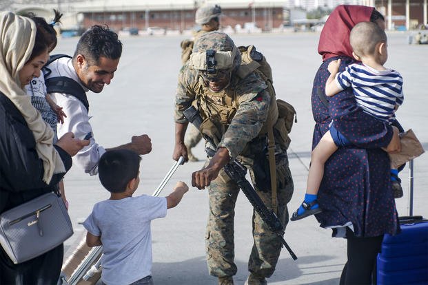 A Marine fists bumps a child evacuee.