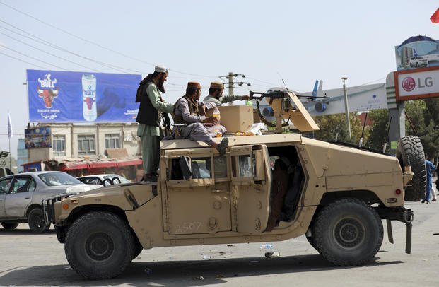 Taliban fighters stand guard in front of the Hamid Karzai International Airport