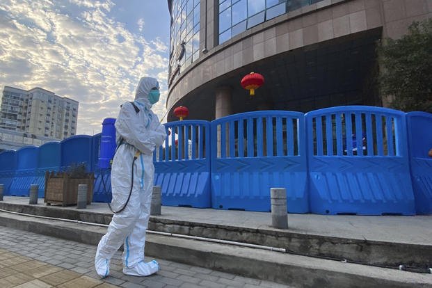 A worker carrying disinfecting equipment walks outside the Wuhan Central Hospital.