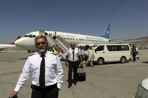 Pilots of Ariana Afghan Airlines walk on the tarmac after landing at Hamid Karzai International Airport in Kabul, Afghanistan.