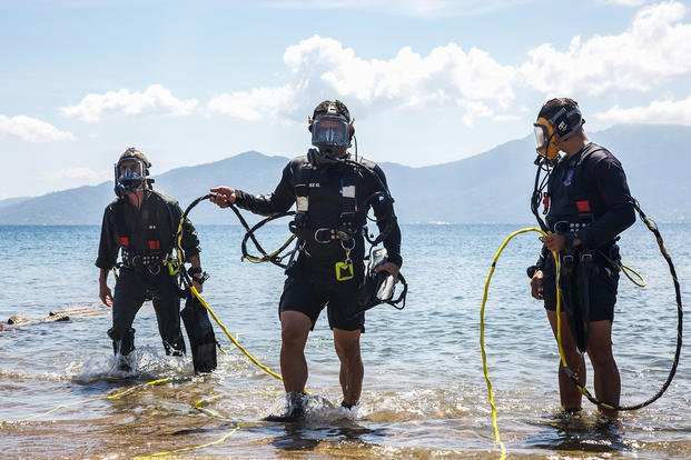 U.S., Honduran service members emerge from the water after a successful dive.
