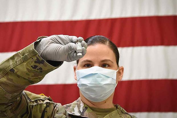 Soldier preps vial of COVID-19 vaccine