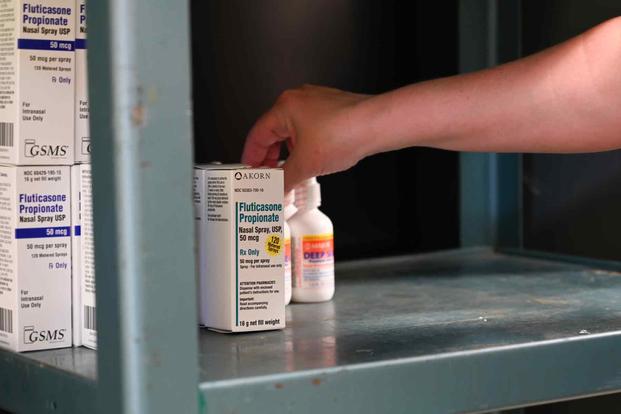 An airman sets up medication in the pharmacy