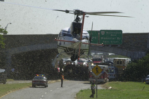 An emergency response helicopter lands on Columbia Pike outside of the Pentagon, 11 September 2001