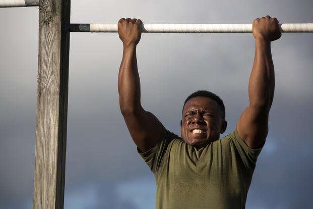 Marine participates in a pull-up competition.