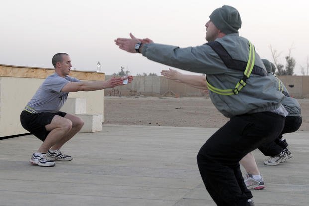 Specialist performs squats during workout in Iraq.