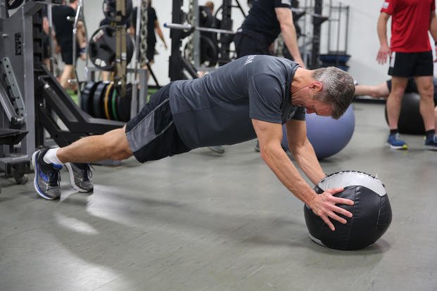 Army general performs a medicine ball rollout.