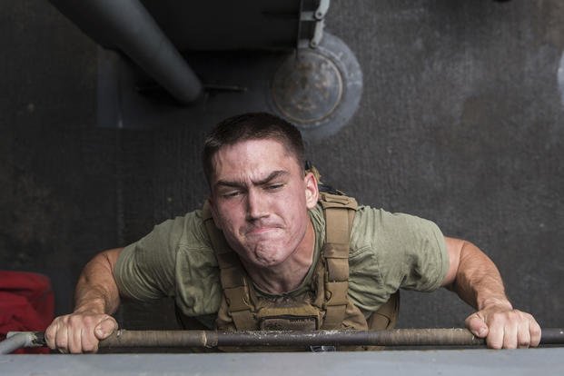 Marine performs a pull-up during the Murph Challenge.