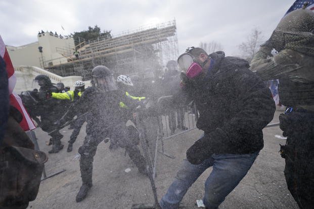 Trump supporters try to break through a police barrier at the Capitol