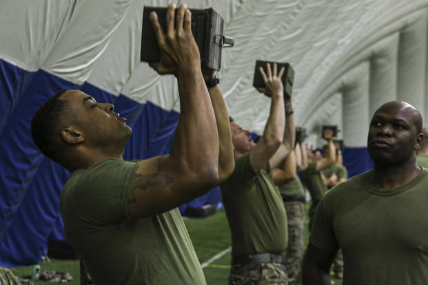 Marine recruiters perform ammunition can lifts.