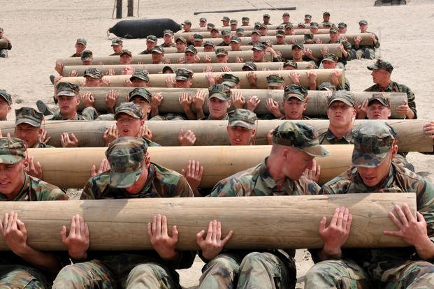 BUD/S candidates carry logs as part of physical training.