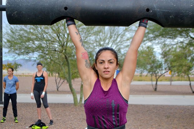 A soldier competes in the log press during the Fort Bliss Strongwoman competition.