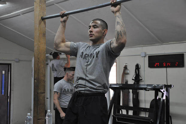 A soldier does overhand pull-ups in Iraq.