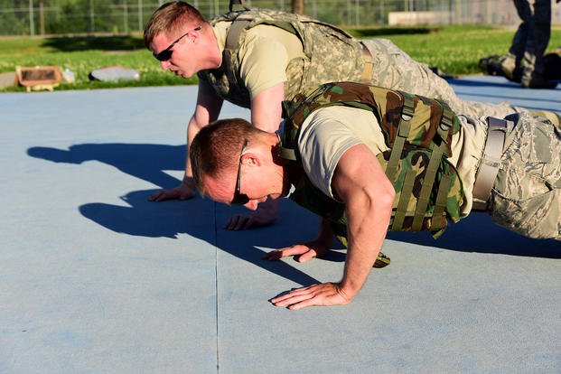 Airmen wear weight vests while doing a challenging workout.