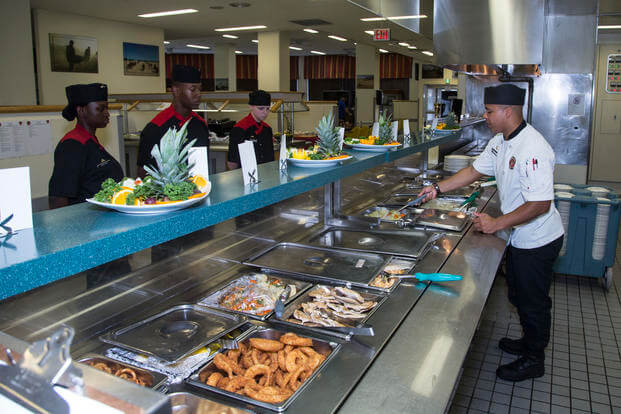 A Marine chief cook goes over the chow line.