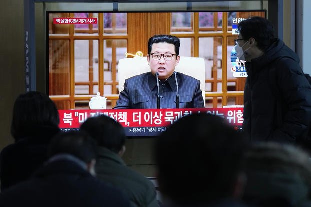 People watch a TV showing a file image of North Korean leader Kim Jong Un