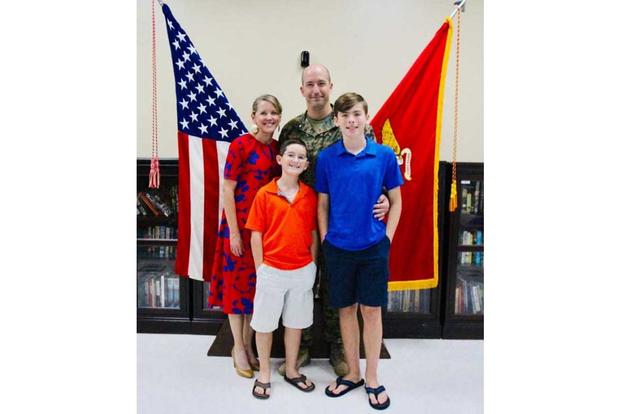 Joshua Plummer with his wife and two sons at his retirement ceremony