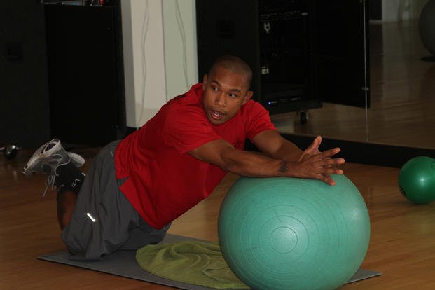 A Semper Fit personal trainer uses a Pilates ball during an abs class.
