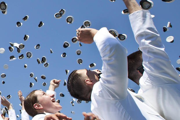 Naval Academy graduates toss their covers into the air during the 2015 Naval Academy graduation and commissioning ceremony.