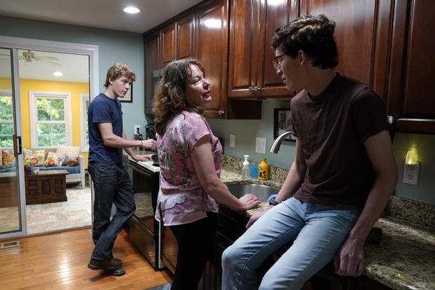 Julie Akey, center, visits with her sons, Sam and Theo, in their home in Herndon, Va.