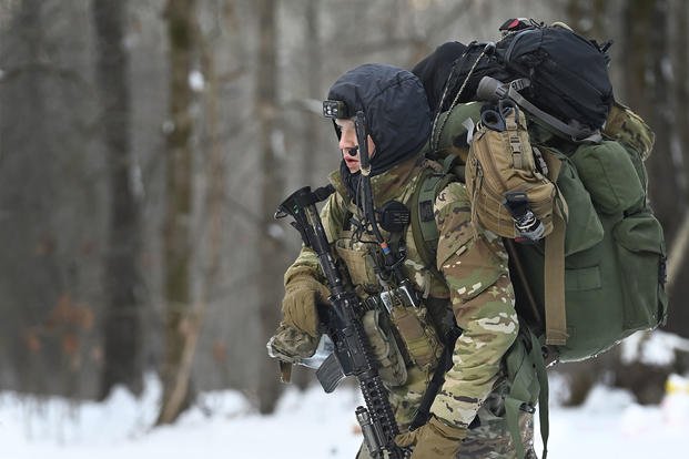 An Army Special Forces candidate hikes through the snow.