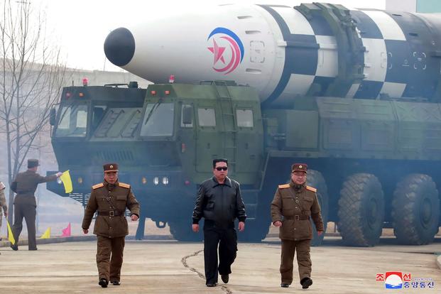 Kim Jong Un walks around what it says a Hwasong-17 intercontinental ballistic missile (ICBM).