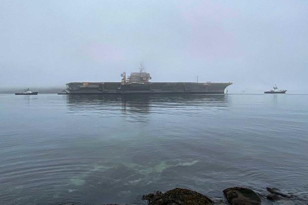 Navy tug boats support the ex-USS Kitty Hawk’s towing in its final transit.