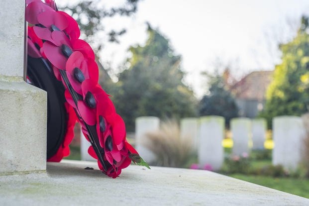 A wreath of red poppies rests on a memorial in the cemetery in England.