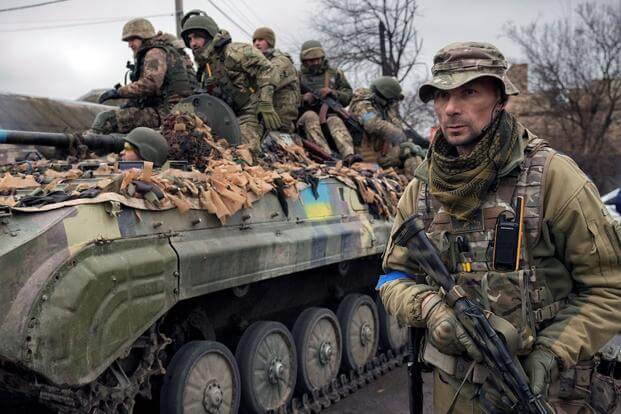 A Ukrainian serviceman walks next to a fighting vehicle, outside Kyiv, Ukraine.