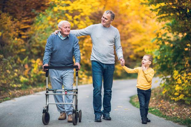 Three generations of men walking through autumn scene