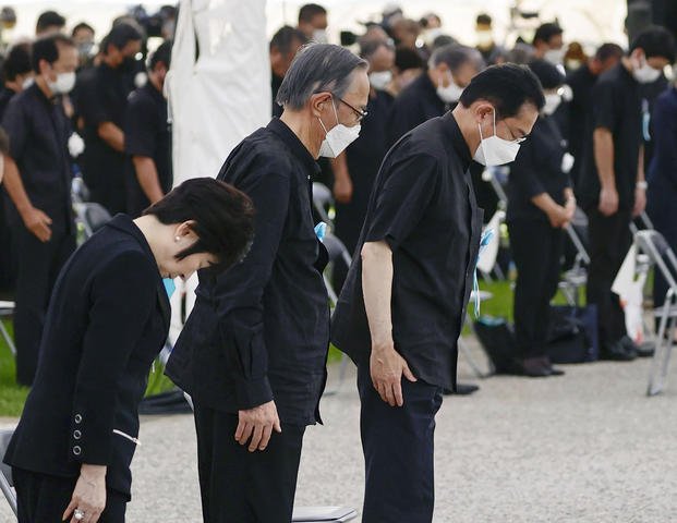 Japan's Prime Minister Fumio Kishida, right, offers a silent prayer during a ceremony