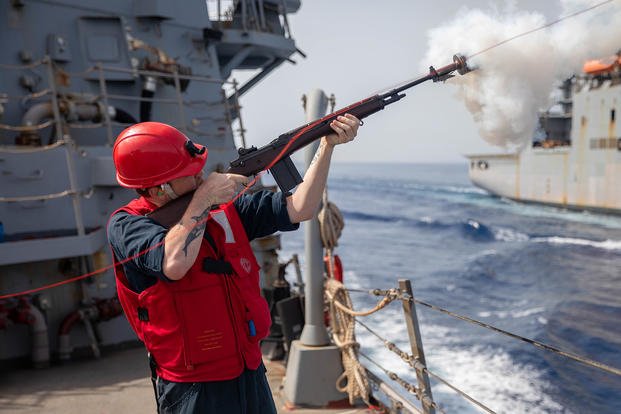 A sailor fires a ‘phone-and-distance shot line’ to USNS Robert E. Peary during an exercise in the Adriatic Sea.