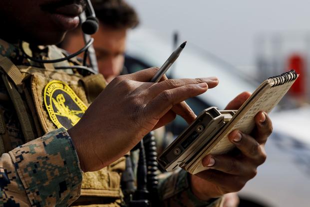 A fire support Marine uses a handheld Link 16 radio.