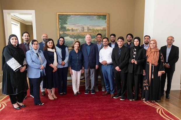 Afzal Afzali stands behind former President George W. Bush.