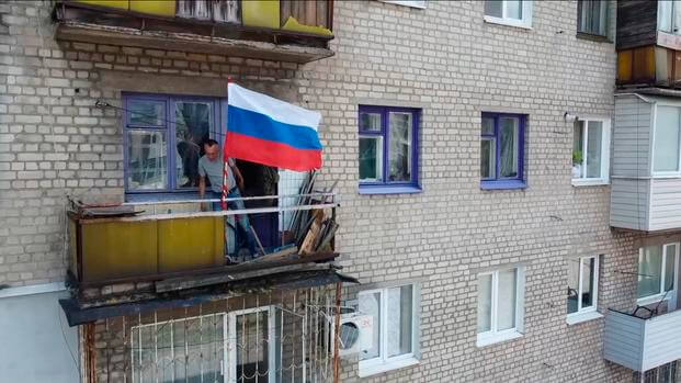 Russian national flag on a balcony of a residential building in Lysychansk