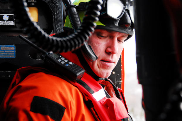 A U.S. Coast Guard rescue swimmer gears up, ready for deployment to an emergency in 2009