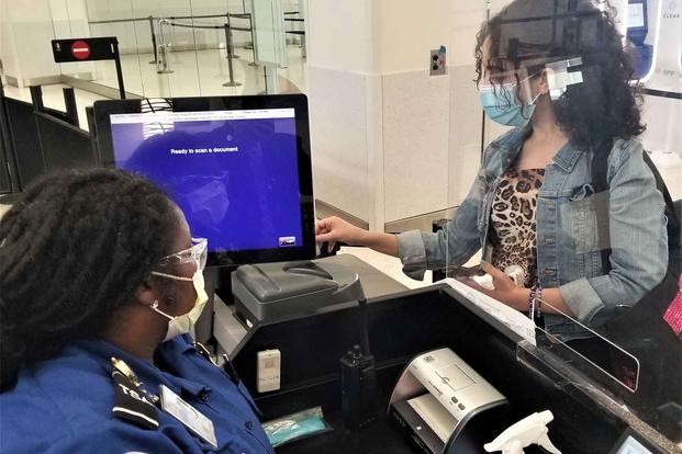 Traveler inserts her driver’s license into a credential authentication technology unit.