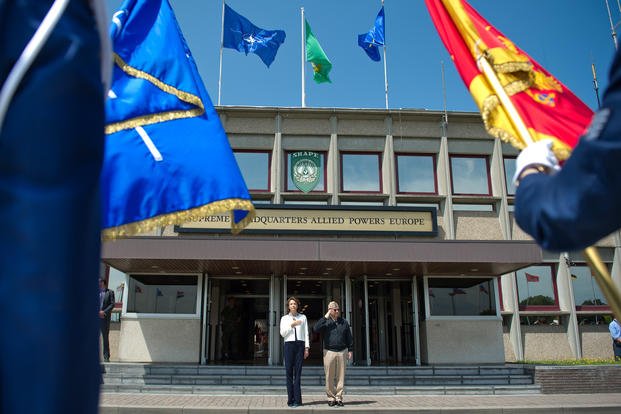 H.E.Ms Milica Pejanovic, Montenegro minister of defense, and Admiral James Stavridis (right side), Supreme Allied Commander Europe, render honors to the Montenegro, NATO and SHAPE flags during the honor guard at Supreme Headquarters Allied Power Europe in Belgium.