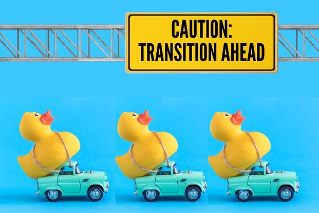 toy cars haul ducks to under sign reading caution transition ahead