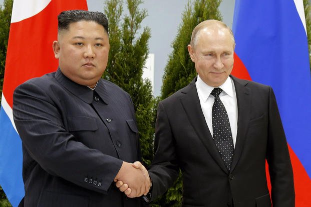 Russian President Vladimir Putin, right, and North Korea's leader Kim Jong Un shake hands