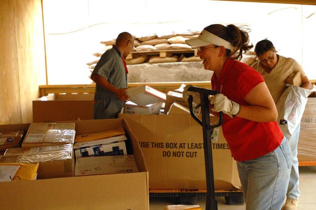 Connie Frank, Forward Operating Base Delta Iraq Post Office employee, moves a tri-wall of mail into the backroom of the post office for sorting after a large shipment.
