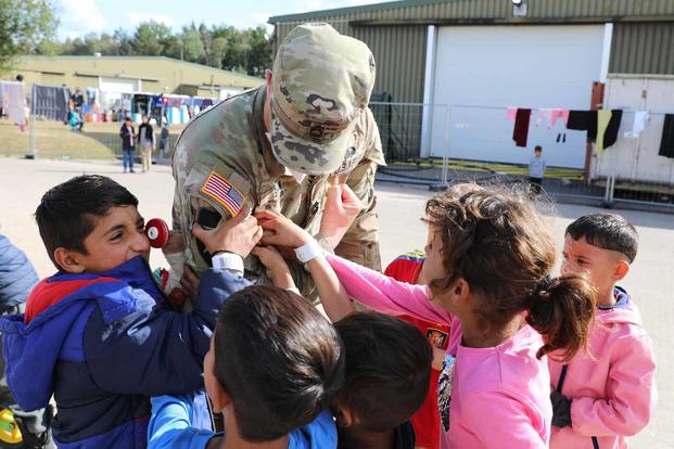 Soldier entertains Afghan children during Operation Allies Welcome, Germany.