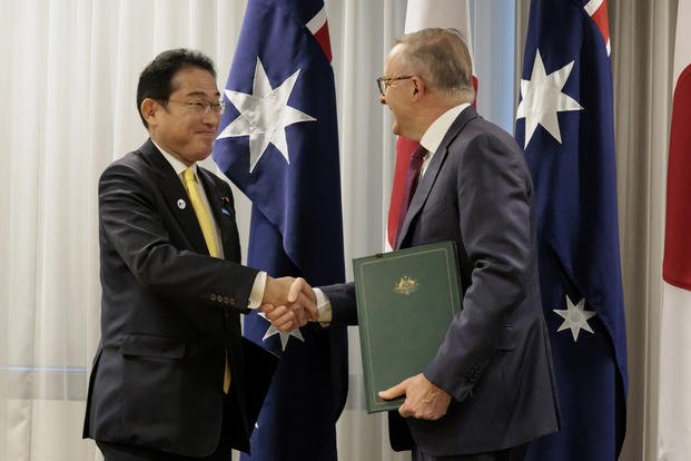 Australian Prime Minister Anthony Albanese shakes hands with Japan's Prime Minister Fumio Kishida.