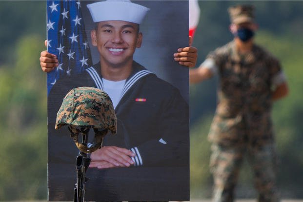 A U.S. Marine with Battalion Landing Team 1/4, 15th Marine Expeditionary Unit, holds the portrait of Navy Hospital Corpsman 3rd Class (Fleet Marine Force) Christopher Gnem, 22, of Stockton, California, during a memorial service at Marine Corps Base Camp Pendleton, California.